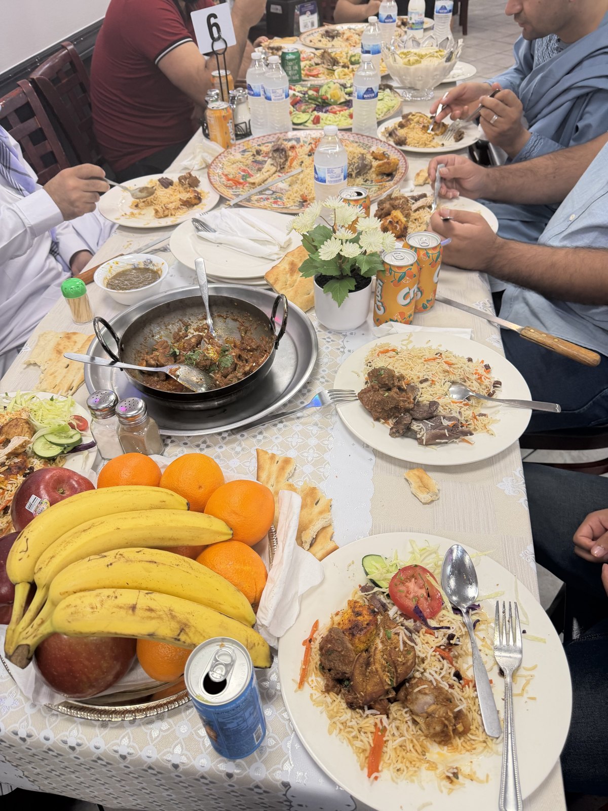 Guests dining together over karahi, palau, and fresh fruit at Afghan House