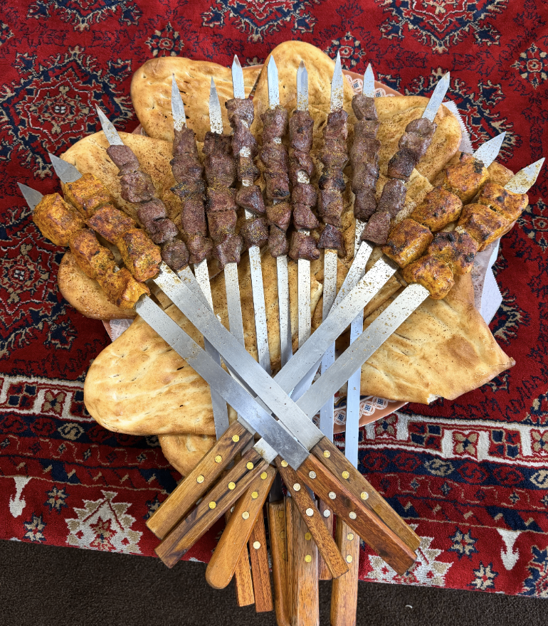 Charcoal-grilled kabob skewers fanned over fresh naan at Afghan House